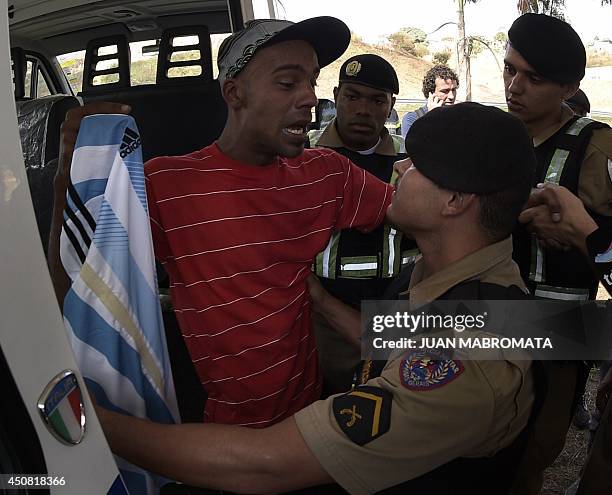 Brazilian supporter of Argentina's forward Lionel Messi is arrested on June 18, 2014 after he managed to enter the Cidade do Galo base camp of the...