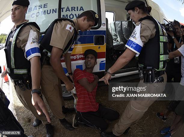 Brazilian supporter of Argentina's forward Lionel Messi is arrested on June 18, 2014 after he managed to enter the Cidade do Galo base camp of the...