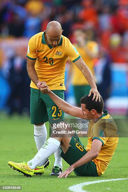 Dejected Mark Bresciano and Ryan McGowan of Australia react after being defeated by the Netherlands 3-2 during the 2014 FIFA World Cup Brazil Group B...