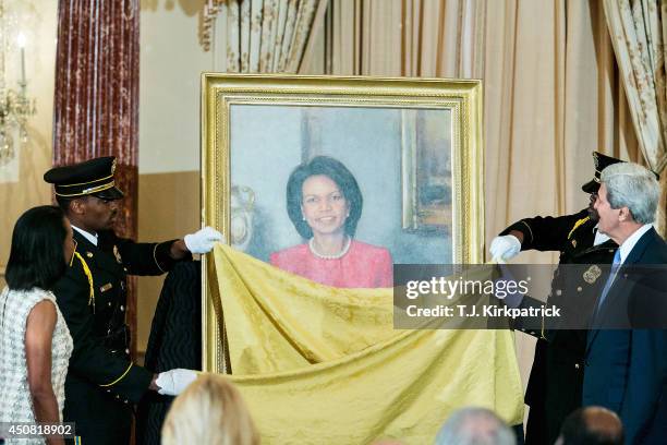 Secretary of State John Kerry, right, and former U.S. Secretary of State Condoleezza Rice, left, watch as Rice's official State Department portrait...