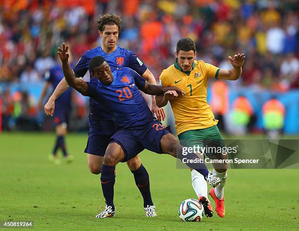 Georginio Wijnaldum of the Netherlands challenges Mathew Leckie of Australia during the 2014 FIFA World Cup Brazil Group B match between Australia...