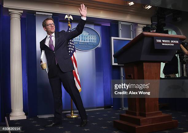 White House Press Secretary Jay Carney waves at the end of his last White House briefing at the James Brady Press Briefing Room of the White House...