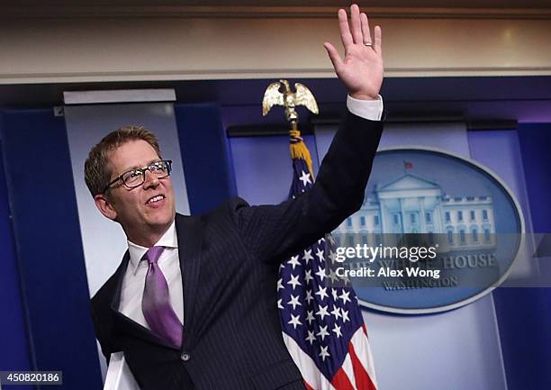 White House Press Secretary Jay Carney waves at the end of his last White House briefing at the James Brady Press Briefing Room of the White House...