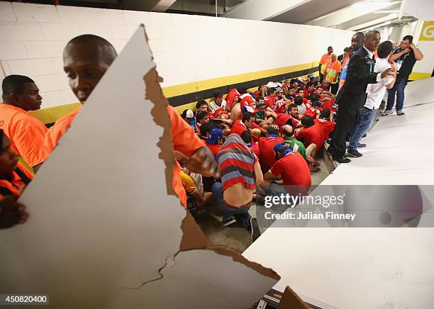 Security personnel attempt to control fans after breaking through security and entering the stadium prior to the 2014 FIFA World Cup Brazil Group B...