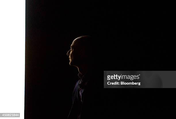 The silhouette of Jeff Bezos, chief executive officer of Amazon.com Inc., is seen as he watches a demonstration of the Fire Phone during an event at...