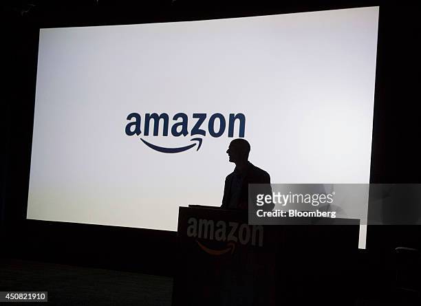 The silhouette of Jeff Bezos, chief executive officer of Amazon.com Inc., is seen as he unveils the Fire Phone during an event at Fremont Studios in...