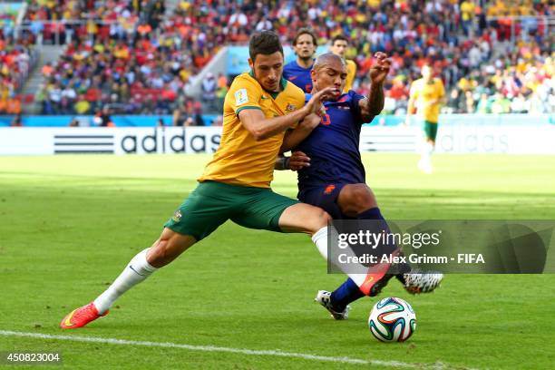 Mathew Leckie of Australia and Nigel de Jong of the Netherlands compete for the ball during the 2014 FIFA World Cup Brazil Group B match between...