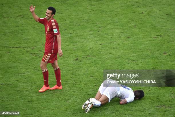 Spain's forward Pedro Rodriguez reacts as Chile's defender Gonzalo Jara lies on the floor following a tackle during a Group B football match between...