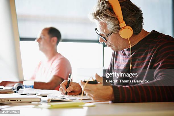 Businessman at desk writing in notepad
