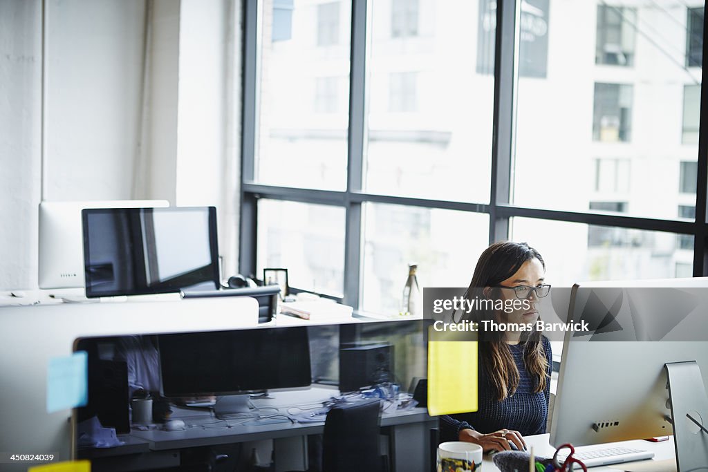 Businesswoman sitting at desk working on computer