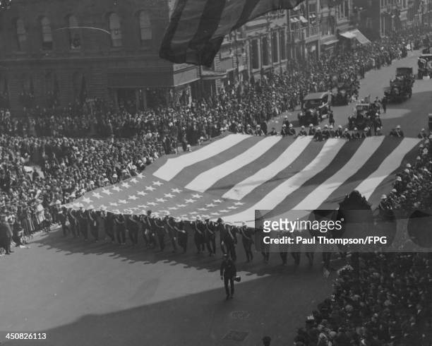Military parade with crowds of excited spectators along 5th Avenue, in celebration of Armistice day and peace in Europe following World War One, New...