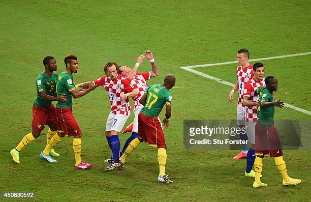 Mario Mandzukic of Croatia falls after competing for position with Stephane Mbia of Cameroon before a corner kick during the 2014 FIFA World Cup...