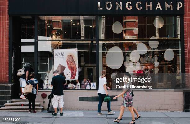 Pedestrians walk past a Longchamp Co. Store in the SoHo neighborhood of New York, U.S., on Wednesday, June 18, 2014. The Bloomberg Consumer Comfort...