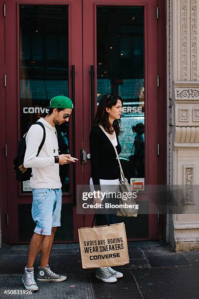 Shoppers stand outside the Converse Inc. Store in the SoHo neighborhood of New York, U.S., on Wednesday, June 18, 2014. The Bloomberg Consumer...