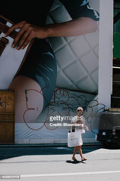 Woman carries a Steve Madden Ltd. Shopping bag while checking her mobile phone in the SoHo neighborhood of New York, U.S., on Wednesday, June 18,...