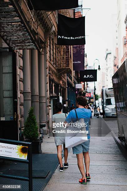 Pedestrian carries a shopping bag while walking in the SoHo neighborhood of New York, U.S., on Wednesday, June 18, 2014. The Bloomberg Consumer...