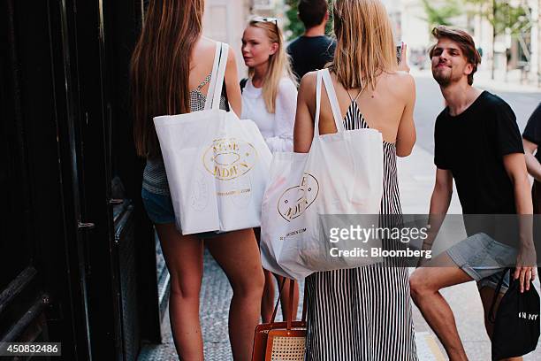 Women hold Steve Madden Ltd. Shopping bags while standing outside of a shop in the SoHo neighborhood of New York, U.S., on Wednesday, June 18, 2014....