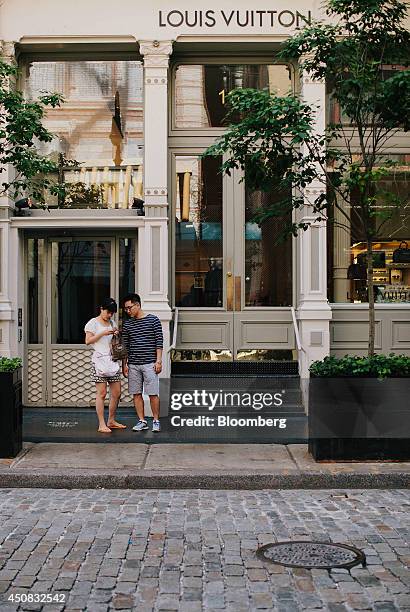 Pedestrians stand outside of a LVMH Moet Hennessy Louis Vuitton SA store in the SoHo neighborhood of New York, U.S., on Wednesday, June 18, 2014. The...