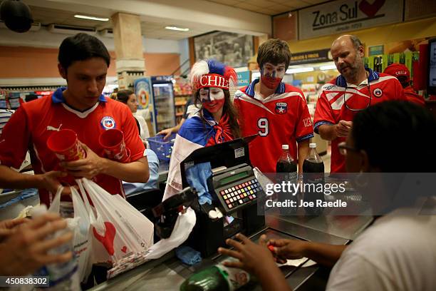 Fernanda Gomez and her brother Agustin Gomez show their support for the Chilean soccer team as they check out at a grocery store after attending the...