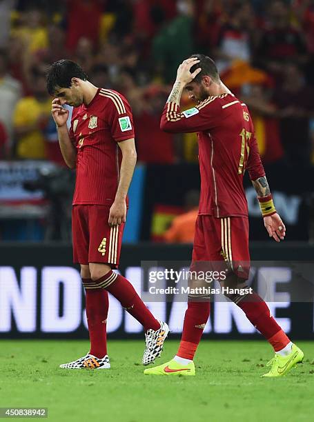Javi Martinez and Sergio Ramos of Spain look dejected in defeat after the 2014 FIFA World Cup Brazil Group B match between Spain and Chile at...
