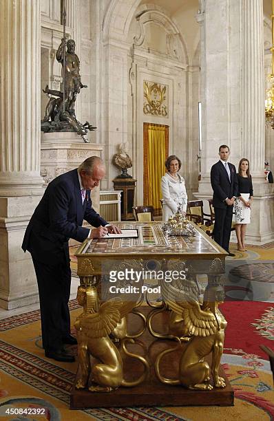 King Juan Carlos of Spain, in the presence of Queen Sofia of Spain, Prince Felipe of Spain and Princess Letizia of Spain, signs the abdication...