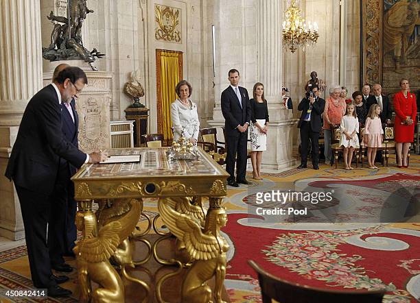 Prime Minister of Spain Mariano Rajoy signs the abdication documents, with Queen Sofia of Spain, Prince Felipe of Spain, Princess Letizia of Spain,...