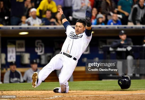 Everth Cabrera of the San Diego Padres slides as he scores during the eighth inning of a baseball game against the Seattle Mariners at Petco Park...