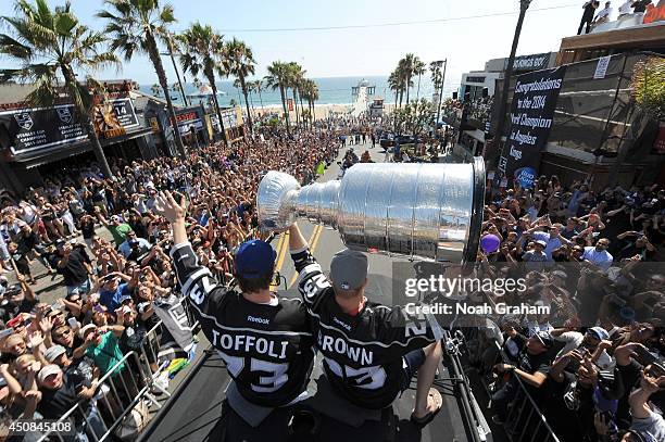 Tyler Toffoli waves to the crowd as Dustin Brown of the Los Angeles Kings hoists the Stanley Cup up in the air during the Los Angeles Kings South Bay...