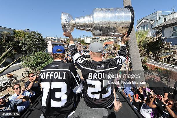 Tyler Toffoli waves to the crowd as Dustin Brown of the Los Angeles Kings hoists the Stanley Cup up in the air during the Los Angeles Kings South Bay...