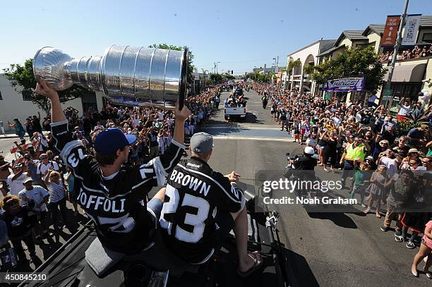 Tyler Toffoli hoists the Stanley Cup as Dustin Brown of the Los Angeles Kings waves to the crowd during the Los Angeles Kings South Bay Victory...