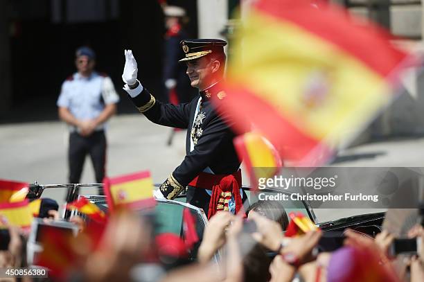 King Felipe VI greets crowds of wellwishers as he arrives at the Royal Palace during the King's official coronation ceremony on June 19, 2014 in...