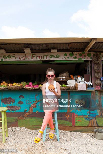 girl sipping coconut at fruit stand - girl who stands stock pictures, royalty-free photos & images