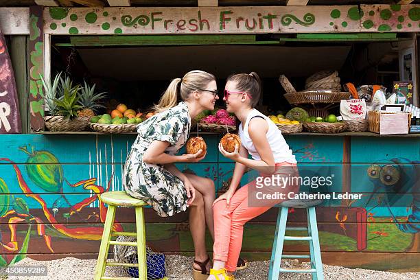 mother and daughter goofing around at fruit stand - hawaii fun fotografías e imágenes de stock