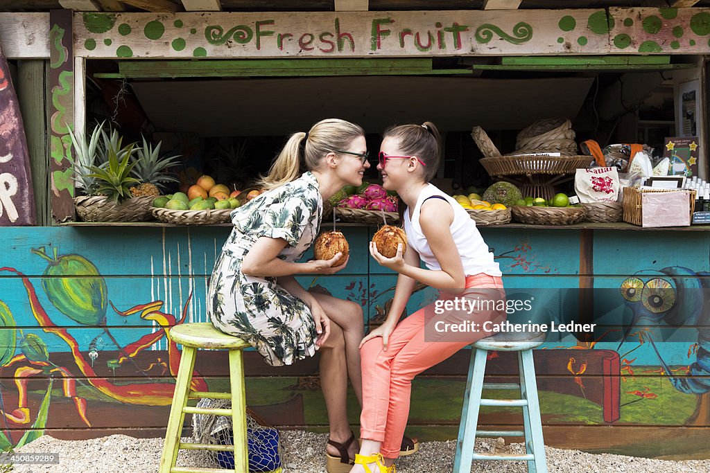 Mother and daughter goofing around at fruit stand