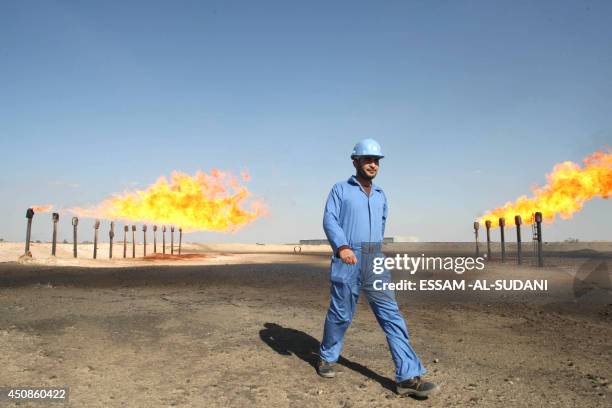 An engineer walks past the chimneys at the Barjisiya oil fields in Zubair One south west of the city of Basra, 550 kms from Baghdad on February 3,...