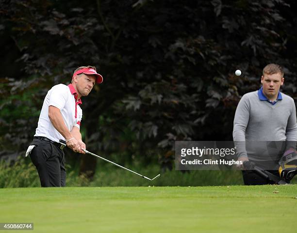 Mark Sparrow of Halfpenny Green Golf Club makes an approach shot onto the 16th green as his caddy looks on during the Golfbreaks.com PGA Fourball...
