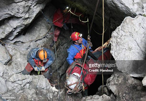 In this handout photo provided by the Bavarian Mountain Patrol , rescue workers bring injured spelunker Johann Westhauser to the surface from the...