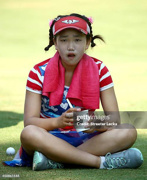 Eleven-year old Amateur Lucy Li of the United States takes a break as she waits to hit on the third hole during the first round of the 69th U.S....