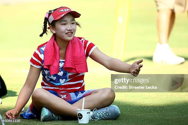 Eleven-year old Amateur Lucy Li of the United States takes a break as she waits to hit on the third hole during the first round of the 69th U.S....