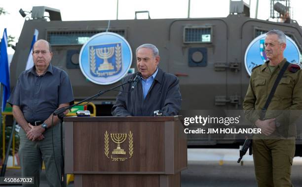 Israeli Prime Minister Benjamin Netanyahu adresses to Israeli army troops flanked by his Defense Minister, Moshe Ya'alon and Chief of Staff Lt. Gen....