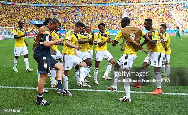 James Rodriguez of Colombia celebrates scoring his team's first goal with his teammates during the 2014 FIFA World Cup Brazil Group C match between...