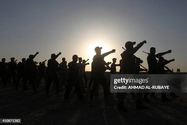 Newly-recruited Iraqi volunteers, loyal to Shiite cleric Moqtada al-Sadr, in army uniforms take part in a training on June 19, 2014 in the capital...