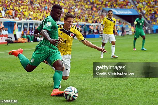 Serge Aurier of the Ivory Coast dribbles past Santiago Arias of Colombia during the 2014 FIFA World Cup Brazil Group C match between Colombia and...