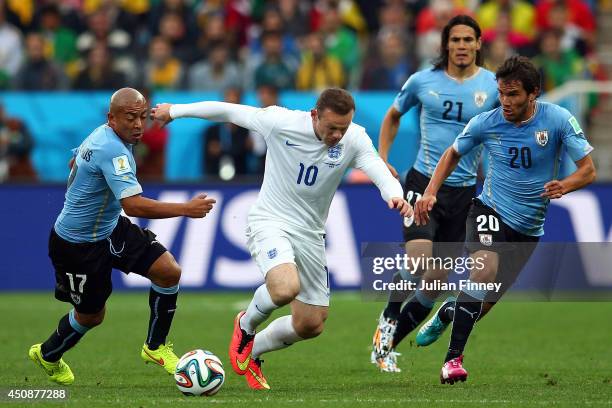 Wayne Rooney of England controls the ball against Egidio Arevalo Rios and Alvaro Gonzalez of Uruguay during the 2014 FIFA World Cup Brazil Group D...