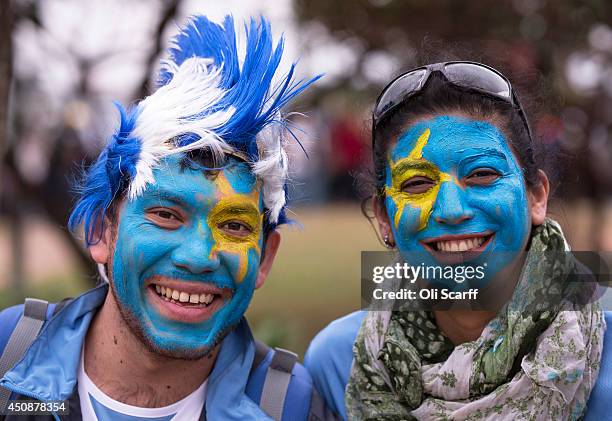 Fans of the Uruguay football team with painted faces pose for a photograph outside the the 'Arena de Sao Paulo' stadium shortly before England's...