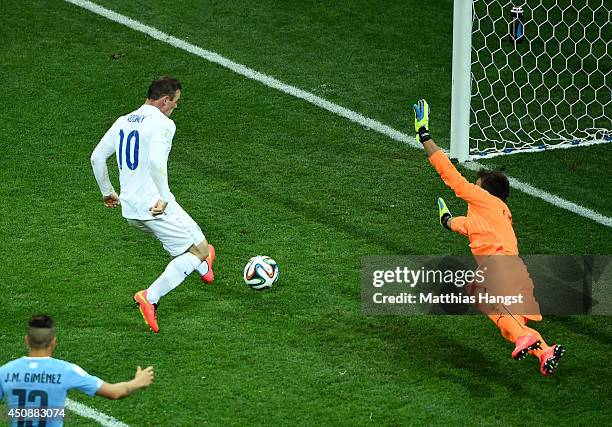 Wayne Rooney of England scores his team's first goal past Fernando Muslera of Uruguay during the 2014 FIFA World Cup Brazil Group D match between...