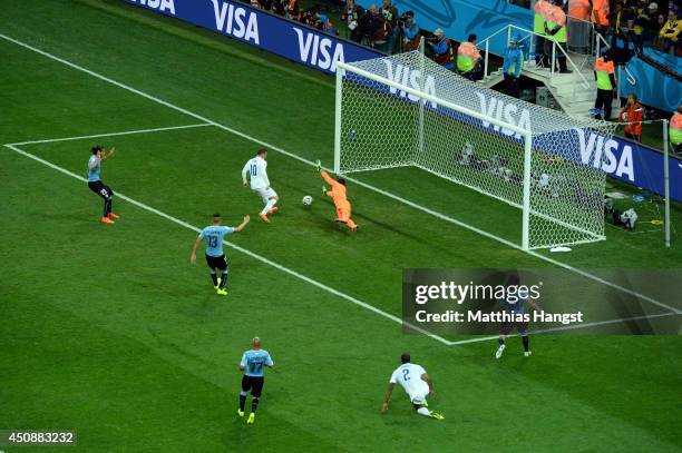 Wayne Rooney of England scores his team's first goal past Fernando Muslera of Uruguay during the 2014 FIFA World Cup Brazil Group D match between...