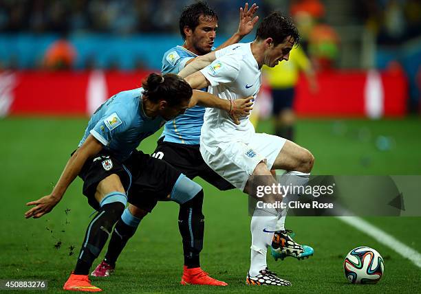 Leighton Baines of England fights off Martin Caceres and Alvaro Gonzalez of Uruguay during the 2014 FIFA World Cup Brazil Group D match between...