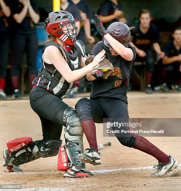 Wells High School catcher Meghan Young holds on to the ball while colliding with Elise Flathers of Cape Elizabeth High School during their Western...