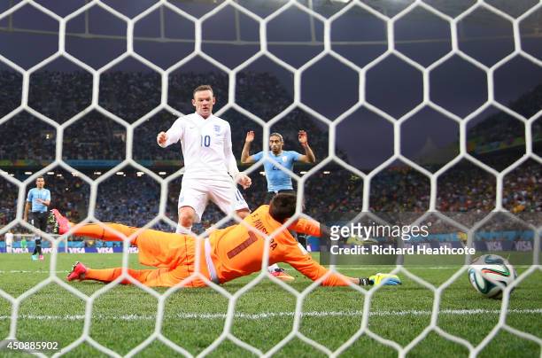 Wayne Rooney of England scores his team's first goal past Fernando Muslera of Uruguay during the 2014 FIFA World Cup Brazil Group D match between...